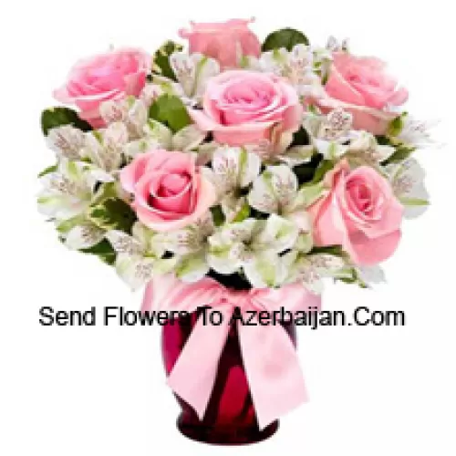 Roses roses et alstroémères blanches arrangées magnifiquement dans un vase en verre