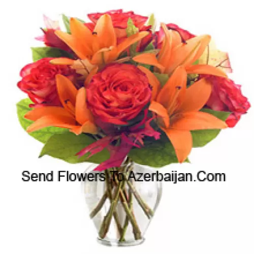 Lys orange et roses orange avec des garnitures saisonnières arrangés magnifiquement dans un vase en verre