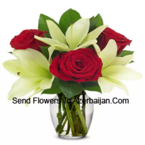 Rose rosse e gigli bianchi con riempitivi stagionali in un vaso di vetro