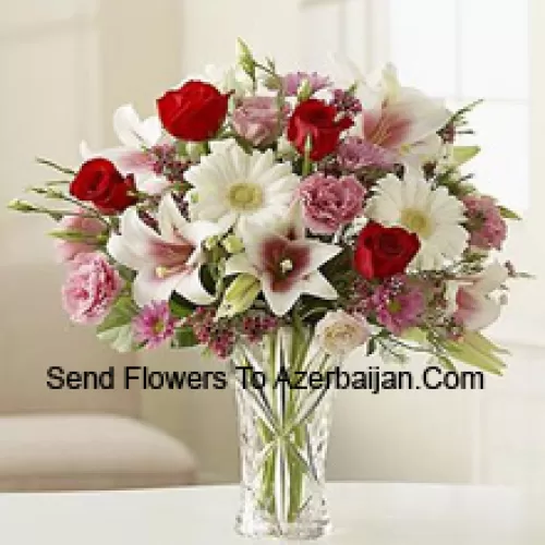 Rote Rosen, rosa Nelken, weiße Gerberas und weiße Lilien mit anderen verschiedenen Blumen in einer Glasvase