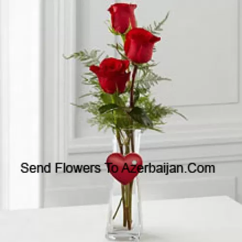 3 Rosas Rojas en un florero de vidrio con un pequeño corazón adjunto
