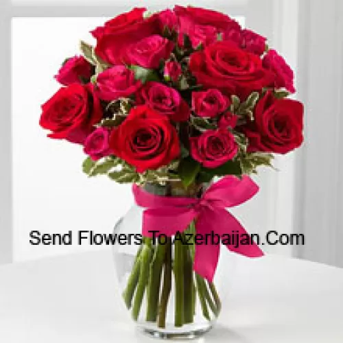 19 Rose Rosse con Riempitivi Stagionali in un Vaso di Vetro Decorato con un Fiocco Rosa